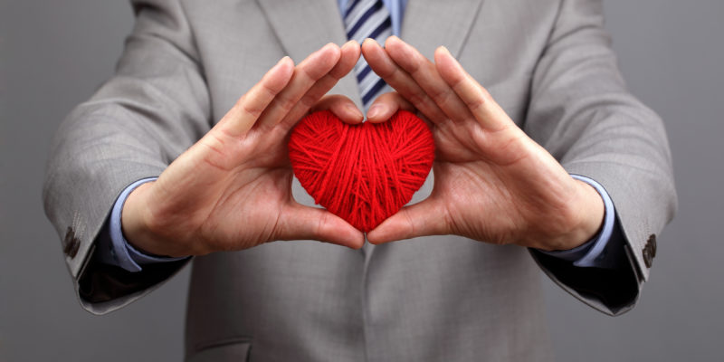 Get Curious: The Key to Killing It in the New Year Man holding a red woolen heart concept for valentine's day, busi