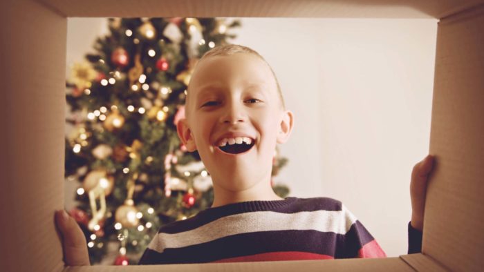 Boy Opening Gift on Christmas from Fostering Christmas