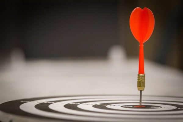 Red dart arrow hitting in the target center of dartboard on bullseye with sun light vintage style, Target marketing and business success concept - Image.
