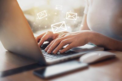 woman writing email copy on laptop