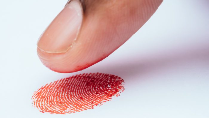 close up of african american man finger printing on white background