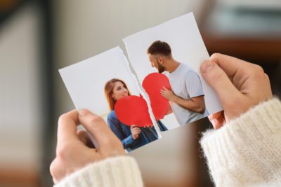 Woman tearing up photo of happy couple, closeup. Concept of divorce