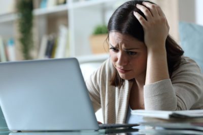 Sad woman complaining checking email on a laptop