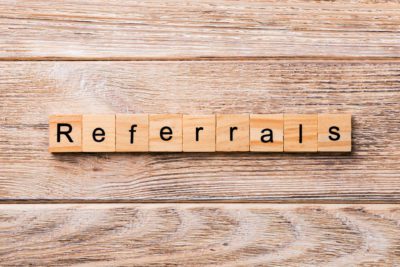 REFERRALS word written on wood block. REFERRALS text on wooden table for your desing, concept.