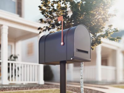 Closed dark mail box with white big house and green tree on background, 3d rendering