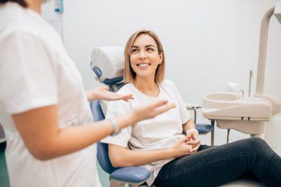 young beautiful lady with blond short hair sit in dentist office, waiting for a teeth treatment. Medicine, dentist concept